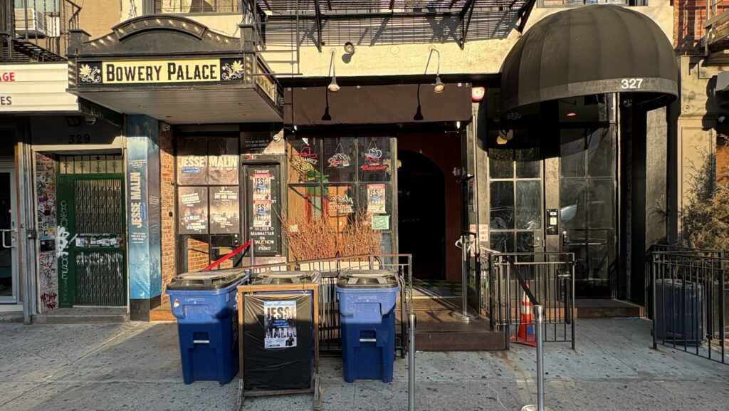 Streetscape showing the exterior of Bowery Palace, featuring the club's marquee and entrance.
