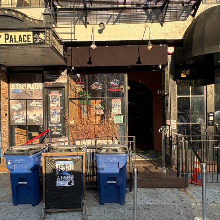 Streetscape showing the exterior of Bowery Palace, featuring the club's marquee and entrance.